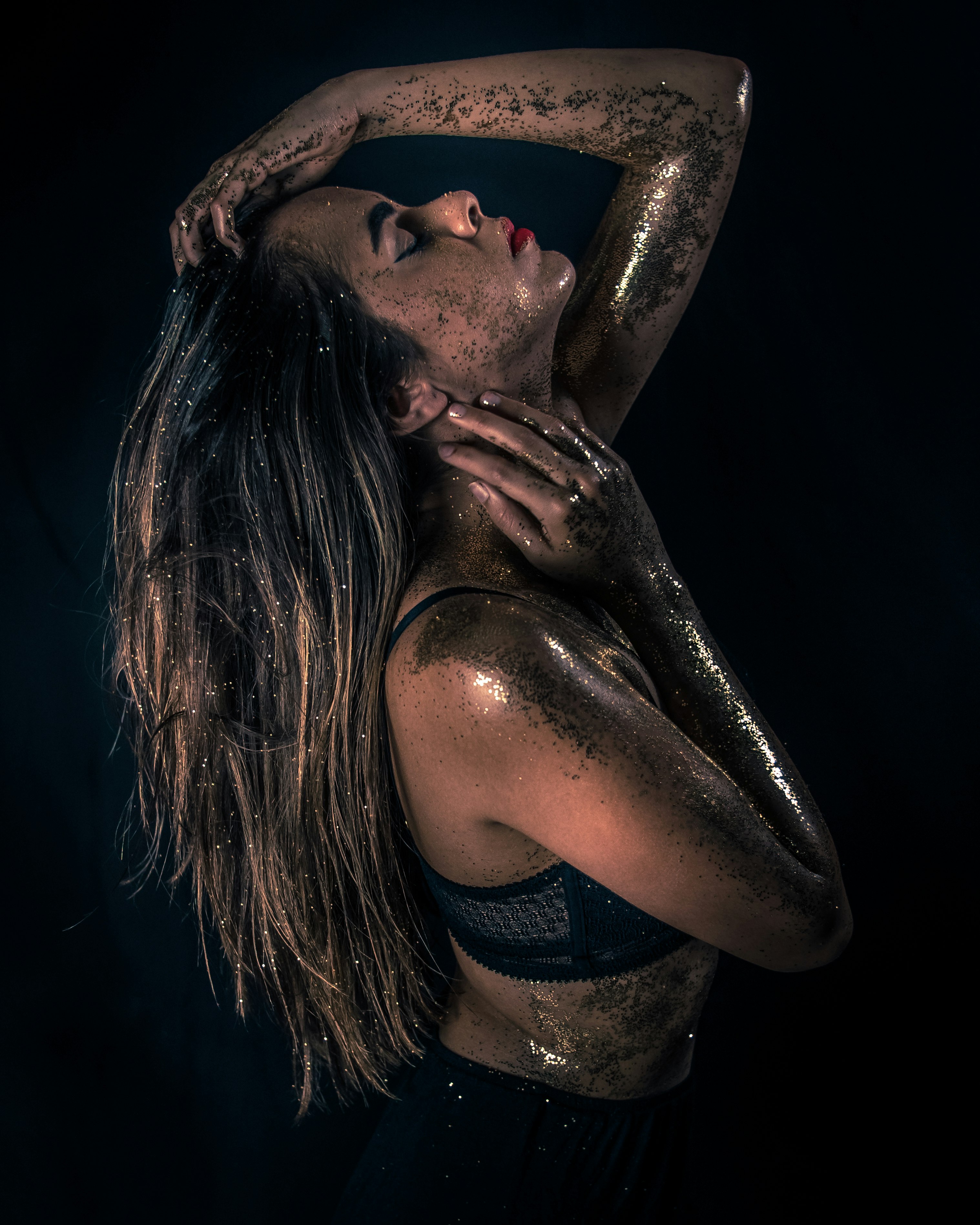 photo of woman raising head covered with gray sequin